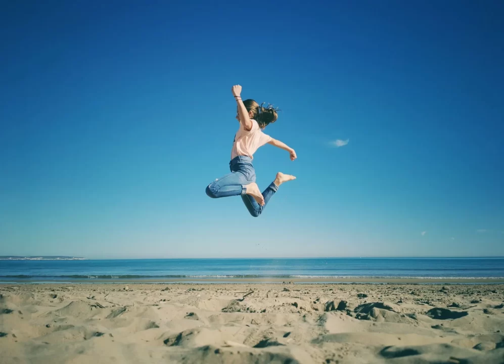 海岸でジャンプしている女性